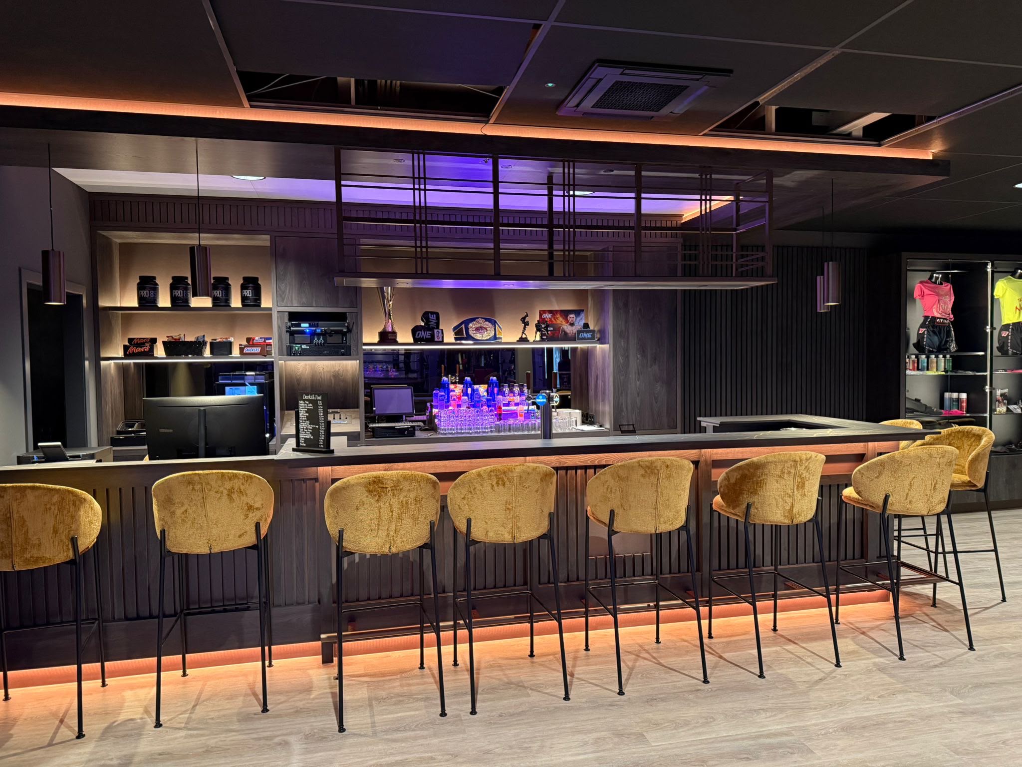 De bar van Team Holzken met zitplaatsen en verlichte presentatie